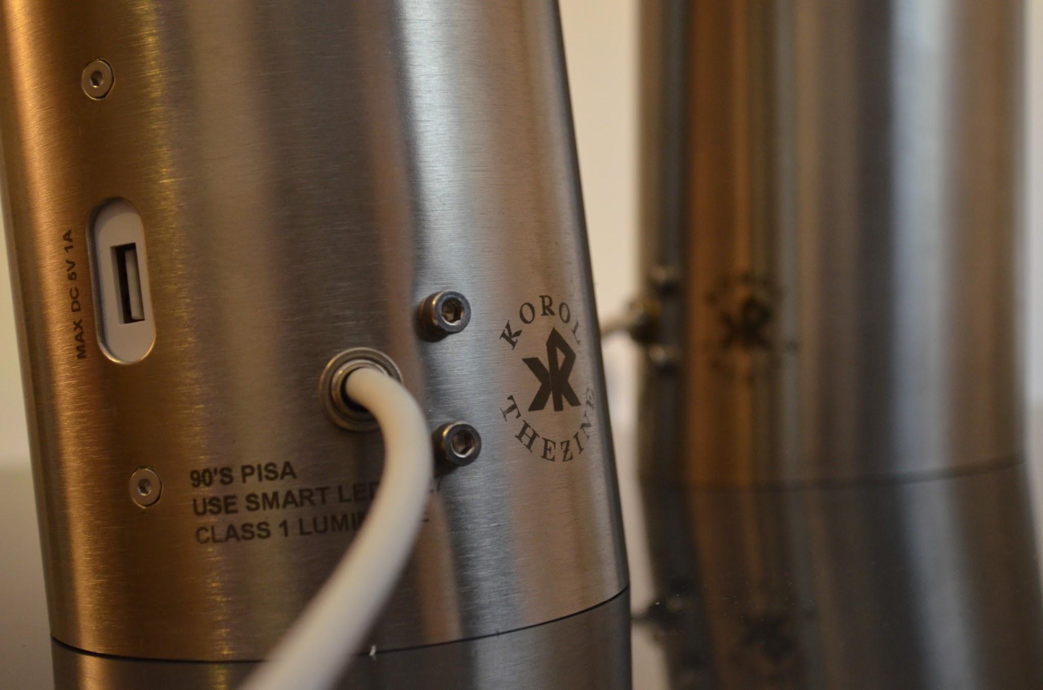 Brushed stainless steel Korol TheZine luminaire glowing in a dark interior